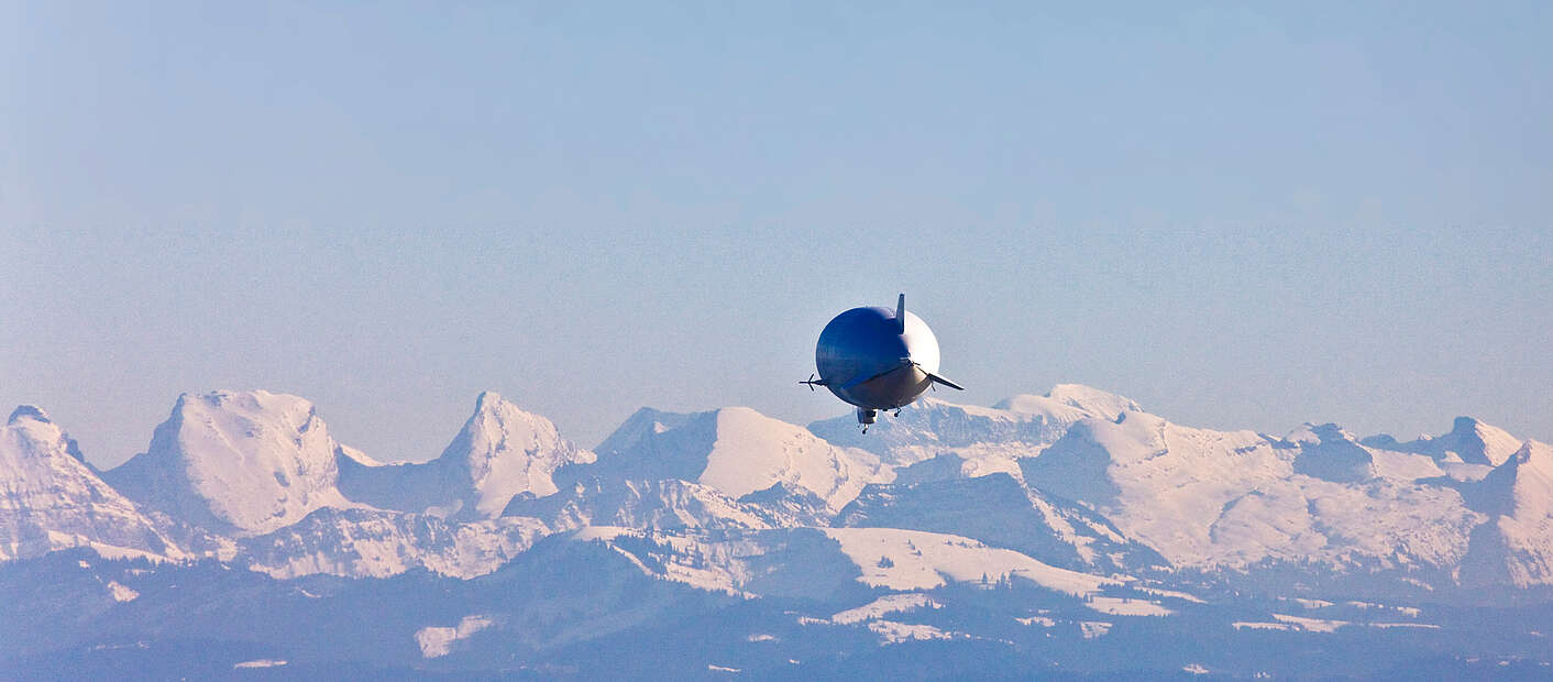 zeppelin über dem See mit Alpenpanorama
