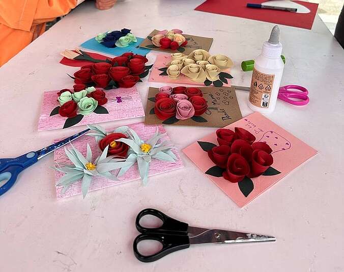 Tisch mit Papierblumen und Schere