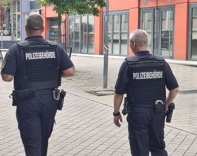 Seit Juli 2025 im Dienst: Zwei Männer vom Kommunalen Ordnungsdient der Stadt Friedrichshafen auf Streife. Rückansicht.