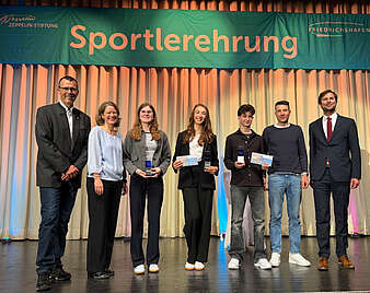 Männer und Frauen auf der Bühne.