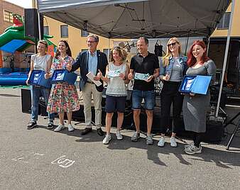 7 Menschen vor einem Straßenstand