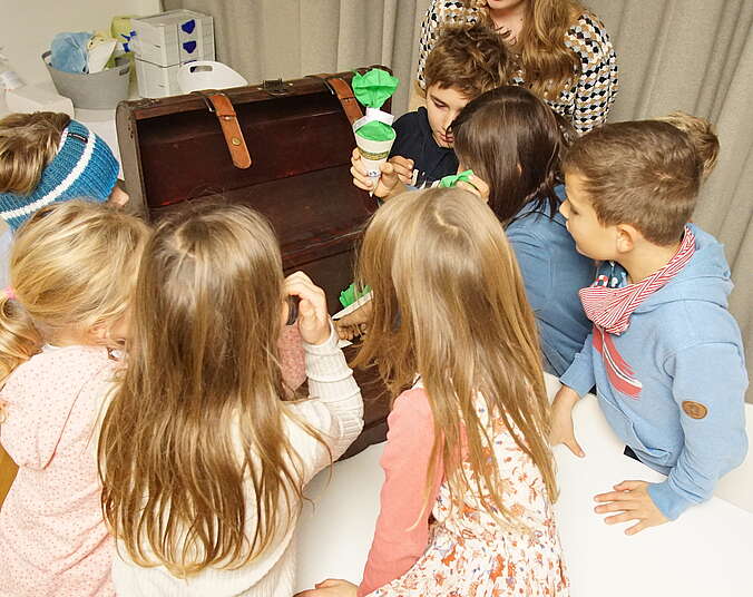Kinder stehen vor einer Schatztruhe