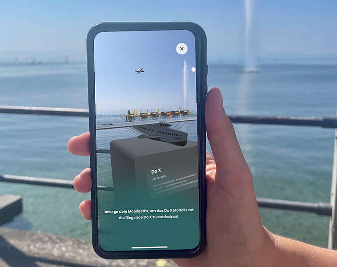 Hand hält IPhone im Hintergrund der See.