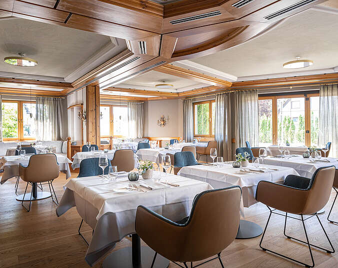 Modern eingerichtetes Restaurant mit stilvoll eingedeckten Tischen.