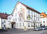 Blick auf das Gasthof Rebstock von der Straße, Haus mit Weintrauben verziert.