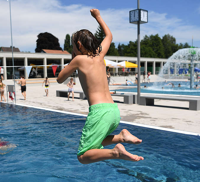 Kind springt ins Wasser im Frei und Seebad Fischbach
