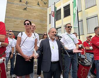 Drei Menschen vor Gebäude