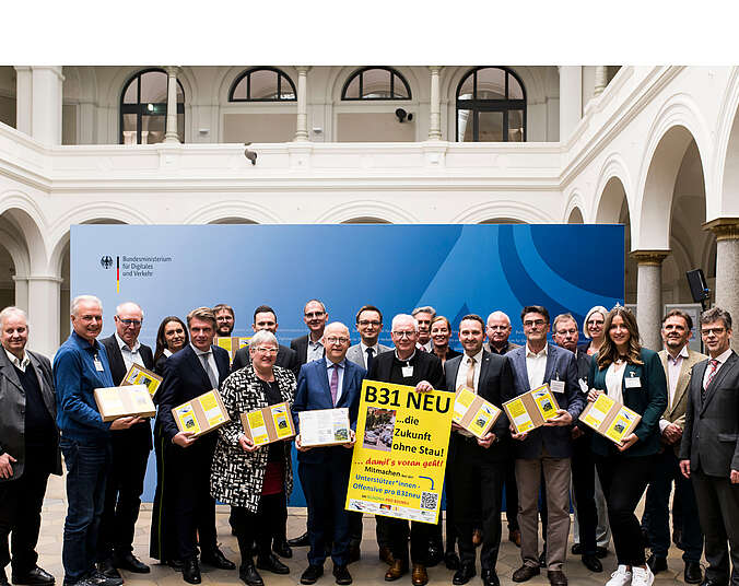 Gruppe mit Plakaten und Flyern im Innenhof des Ministeriumsgebäudes