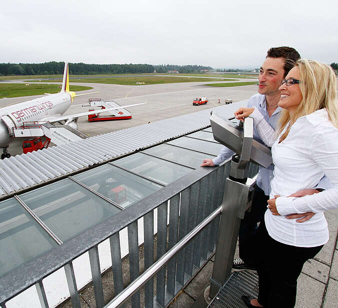 Mann und Frau stehen am Flughafen beobachten Flugzeuge
