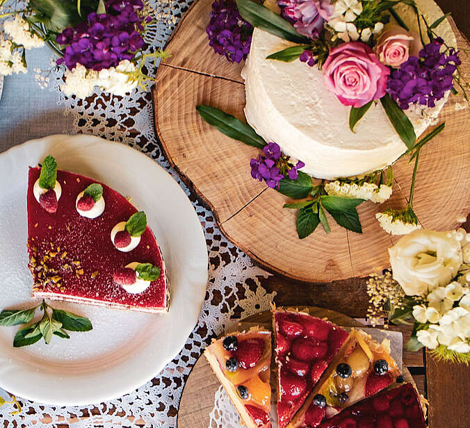 Ein Tisch mit untschiedlich dekotierten Kuchenstücken