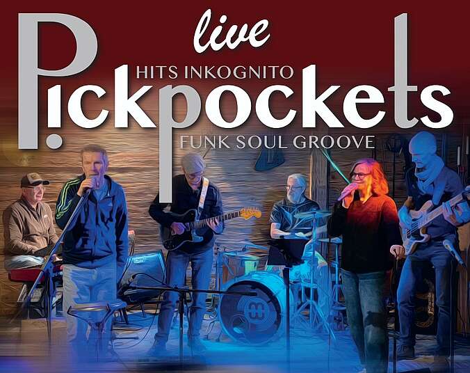 Band auf der Bühne spielt Schlagzeug, Bass und Gitarre