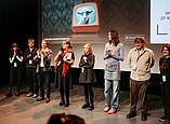Publikumsgespräch während des Wettbewerbs am Festivalsamstag. Zu sehen von links nach rechts: „Die Sache“ – Samuel Müller (Regie) und Sibel Chalkias (Produktion), „SYNCOPE“ – Linus von Stumberg (Regie), Moderatorin Katrin Posse, „Lux Carne“ – Lina Doll (Produktionsdesign) und Yeron Stocker (Kostüme), „Die Kruste“ – Jens Kevin Georg (Regie) und Lea Agmon (Szenenbild).
