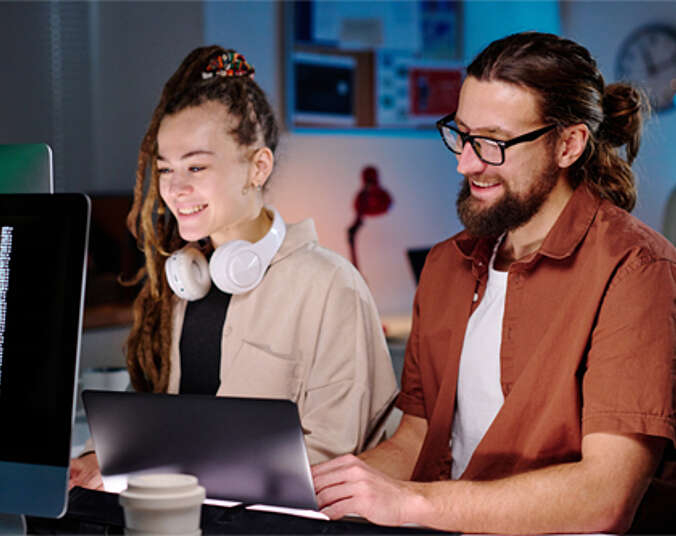 Zwei lachende Informatiker am Arbeitsplatz