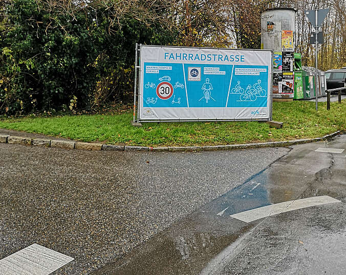Blaues Banner auf dem Grünstreifen am Straßenrand mit Hinweisen auf die Fahrradstraße