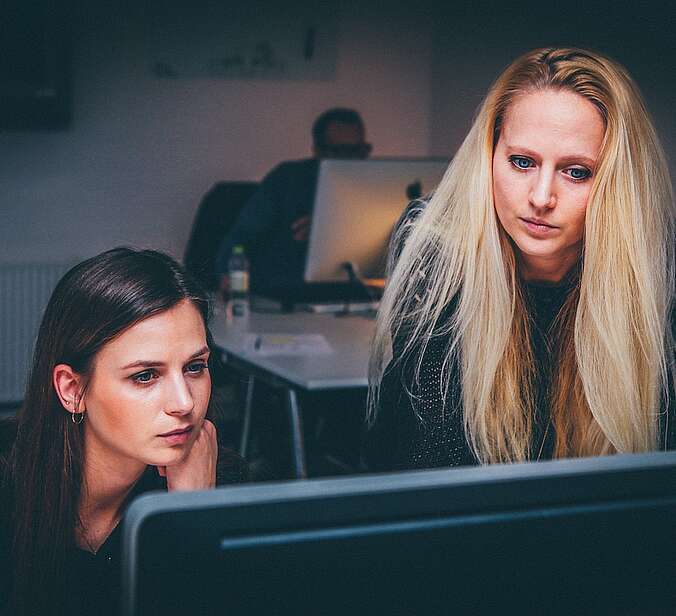 Junge Frauen schauen auf Monitor