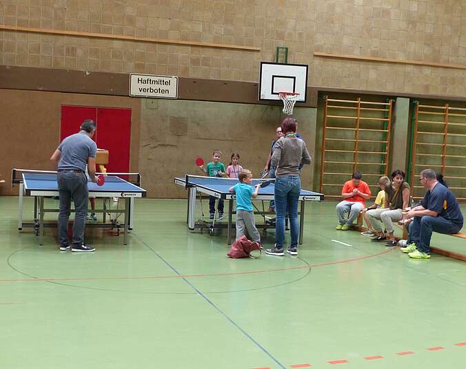 Kinder und Erwachsene beim Tischtennis spielen