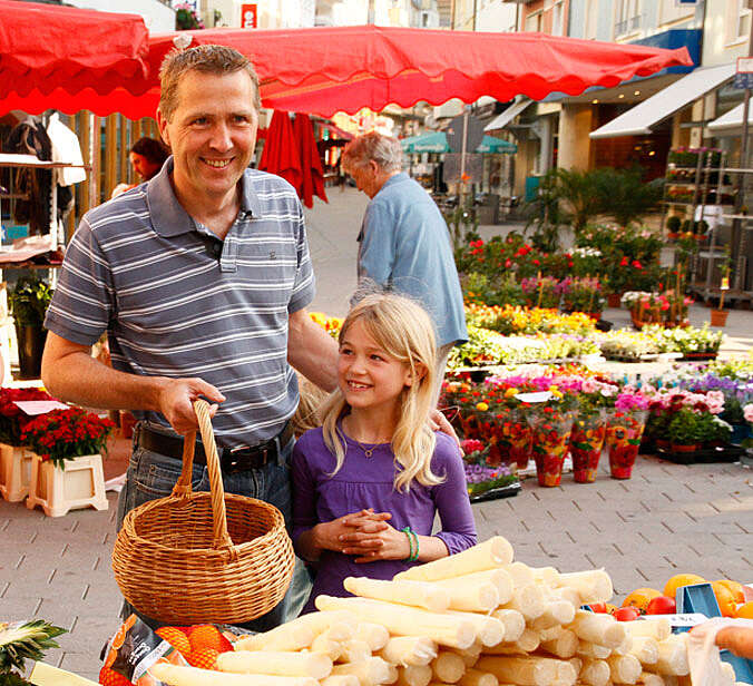 Papa Kind stehen vor Spargelstand beim Wochenmarkt