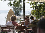 zwei junge Leute sitzen im Café am See
