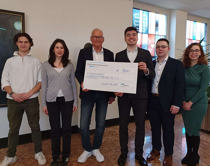 Mitglieder des Jugendparlaments und Herr Büchelmaier halten großen weißen Scheck in den Händen.