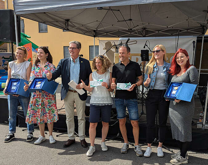 Frauen und Männer halten die Preise in den Händen, die sie für die Teilnahme am Stadtradeln erhalten haben.