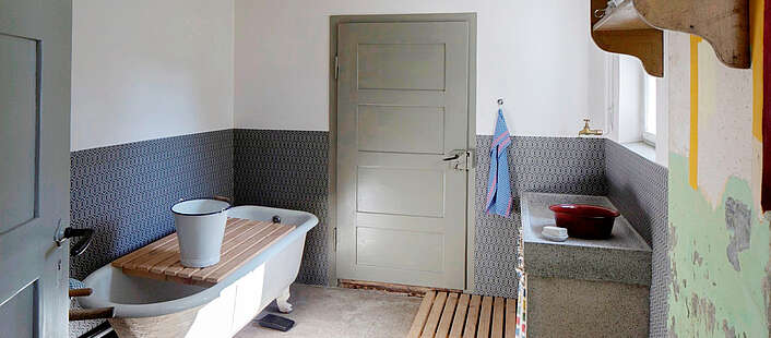 Innenansicht der Spül- und Waschküch des Schauhauses mit alter Badewanne und historische Spüle.