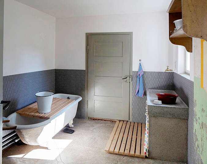 Innenansicht der Spül- und Waschküch des Schauhauses mit alter Badewanne und historische Spüle.