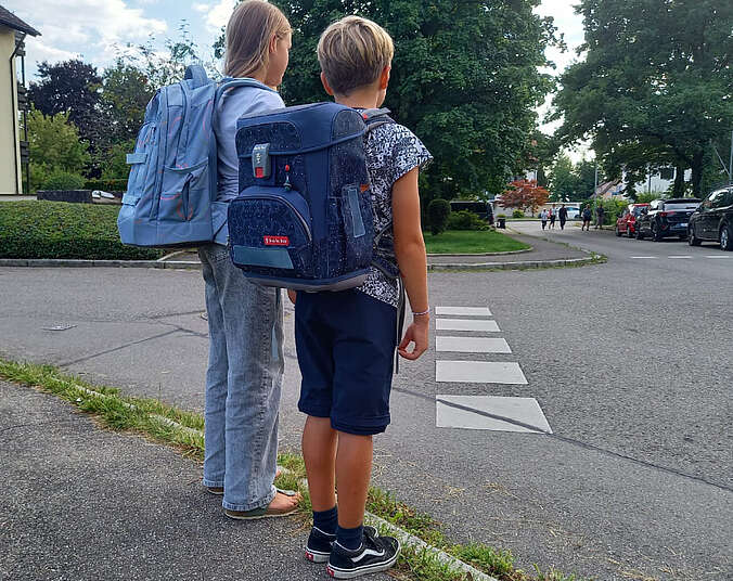 Zwei Kinder stehen an der Straße.