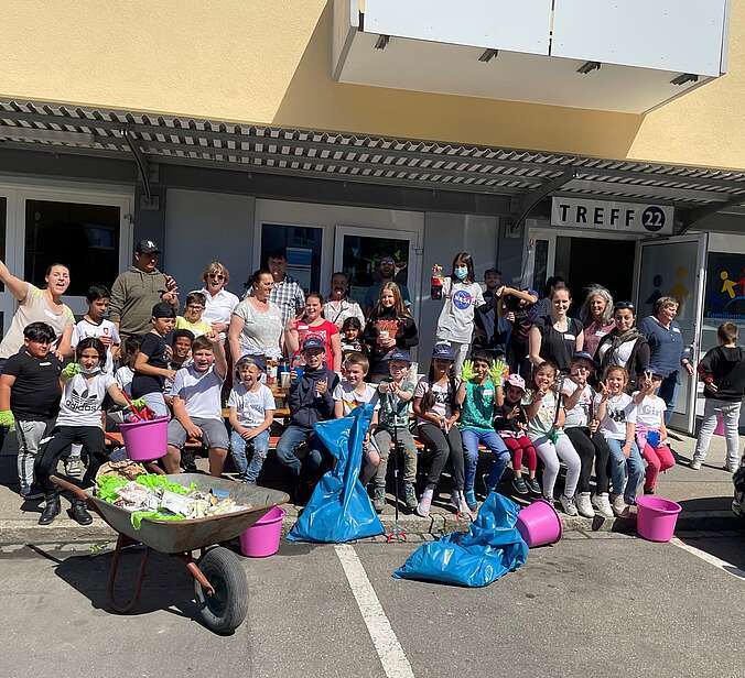 Gruppe Menschen mit Schubkarre vor einem Familientreff