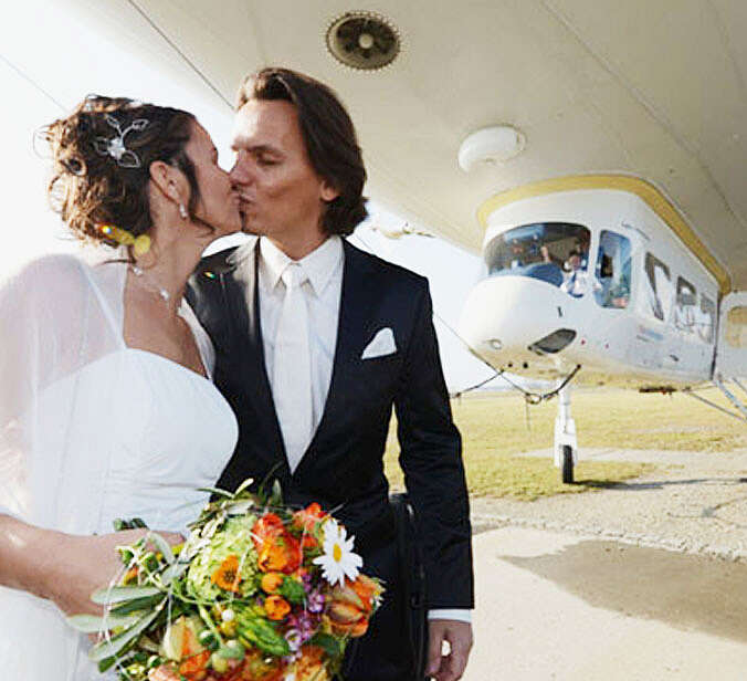 Hochzeitspaar steht vor einem Zeppelin