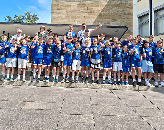 Junge Fußballer in blauen Shirts vor dem Rathaus gemeinsam mit OB Blümcke.