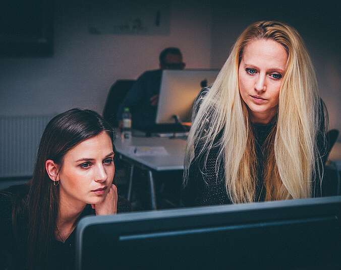 zwei Frauen schauen auf einen Computer