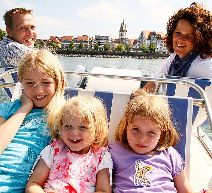 Mann und Frau drei Kinder auf Tretboot auf dem See